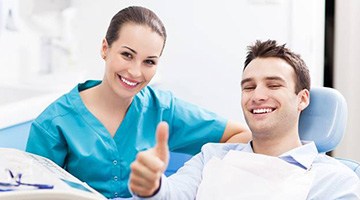 Man in dental chair giving thumbs up