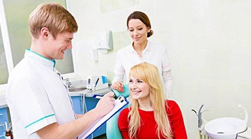 Smiling woman in dental chair talking to dentist