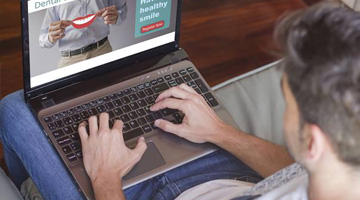 Man looking at dental insurance information on laptop