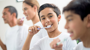 young family brushing teeth