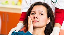 Woman holding cheek in pain