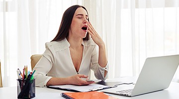 Yawning woman at computer